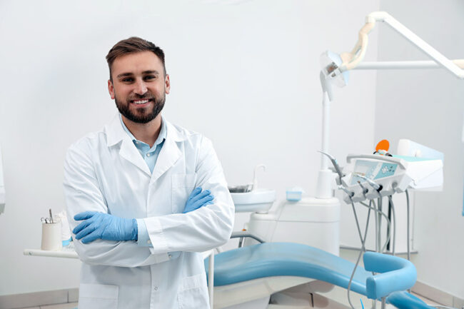 Portrait of professional dentist at workplace in clinic