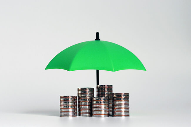 A pile of coins with an open blue umbrella.