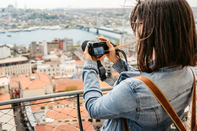 Young Woman Taking Pictures Of The Galata Bridge In Istanbul