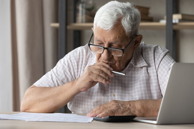 Older man holds pen learn written information in document