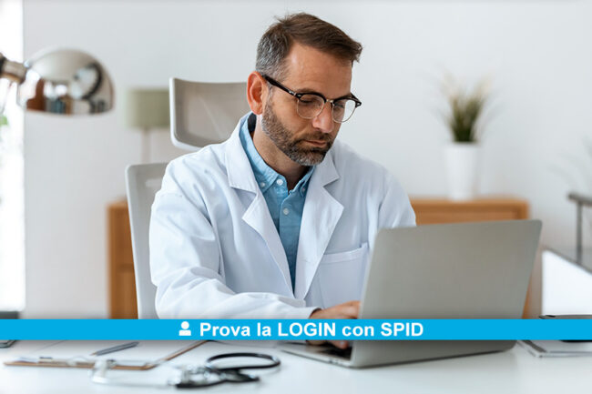 Mature concentrated attractive male doctor working with her computer in medical consultation.
