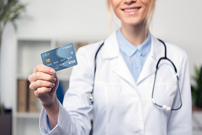 Cropped shot of smiling young doctor holding blank business card