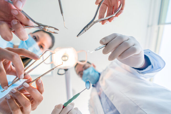 Group of dental surgeons holding tools