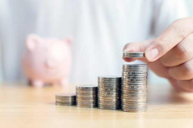 Concept save money financial business investment. Hand of male putting coins stack step growing growth value with piggy bank