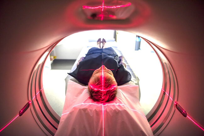Patient lying inside a medical scanner in hospital