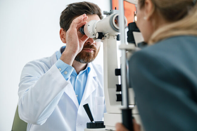 Optometrist checks the patient’s intraocular pressure in optician’s shop or ophthalmology clinic